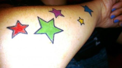 tatuagem estrelas coloridas no braco